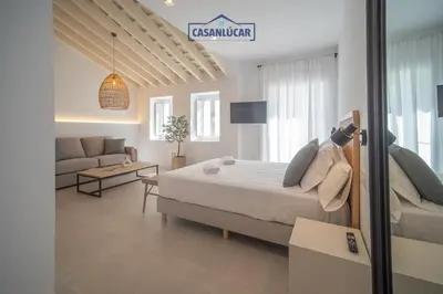 a bedroom with a bed and a living room at Sanlucar Centro - Apartamento 4 in Sanlúcar de Barrameda