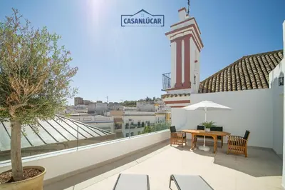a balcony with a table and chairs on a building at Sanlucar Centro - Apartamento 5 in Sanlúcar de Barrameda