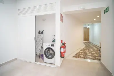 a laundry room with a washer and dryer next to a hallway at Sanlucar Centro - Apartamento 5 in Sanlúcar de Barrameda