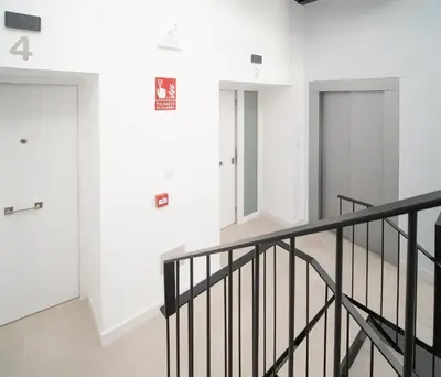 a staircase in a building with white walls and doors at Sanlucar Centro - Apartamento 5 in Sanlúcar de Barrameda