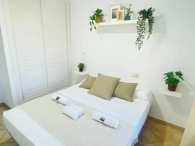 a white bed with two pillows on it in a room at La Almadraba in Chiclana de la Frontera