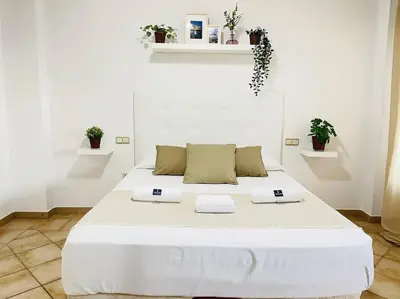 a white bedroom with a large white bed at La Almadraba in Chiclana de la Frontera