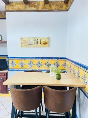 a wooden table with two chairs in a kitchen at La Almadraba in Chiclana de la Frontera