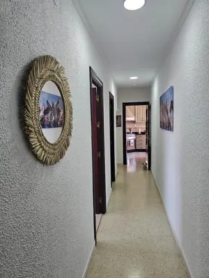 a hallway with a gold mirror on a wall at Apartamento Granja - a 5 min de la playa in Cádiz
