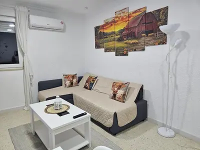 a living room with a bed and a table at Apartamento Granja - a 5 min de la playa in Cádiz