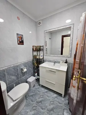 a bathroom with a sink and a toilet and a mirror at Apartamento Granja - a 5 min de la playa in Cádiz
