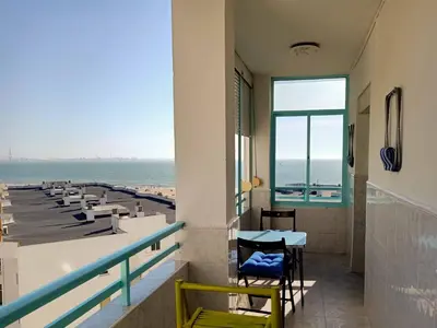 a balcony with a table and chairs and the ocean at Azvalia Puerto Príncipe 2 in El Puerto de Santa María