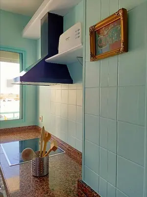 a kitchen with blue walls and a counter top at Azvalia Puerto Príncipe 2 in El Puerto de Santa María
