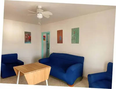 a living room with two blue chairs and a table at Azvalia Puerto Príncipe 2 in El Puerto de Santa María