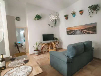 a living room with a blue couch and a tv at Apartamento en pleno centro historico in Cádiz