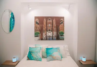 a bedroom with a bed with a painting on the wall at Apartamento en pleno centro historico in Cádiz