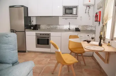 a kitchen with a table and two chairs and a dining room at Apartamento en pleno centro historico in Cádiz