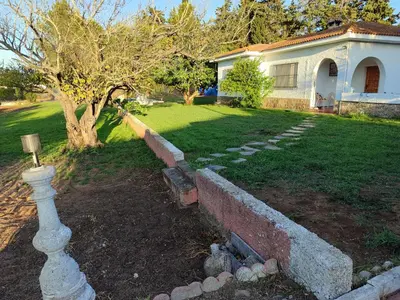 a yard with a stone wall and a house at villa eloisa in Chiclana de la Frontera