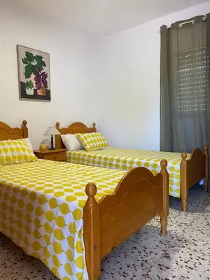 a bedroom with two beds with yellow and white sheets at villa eloisa in Chiclana de la Frontera