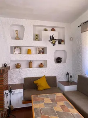 a living room with a couch and a table and shelves at villa eloisa in Chiclana de la Frontera