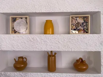 a shelf with two vases and pictures on it at villa eloisa in Chiclana de la Frontera