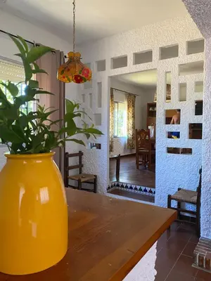 a yellow vase sitting on a wooden table with a plant at villa eloisa in Chiclana de la Frontera