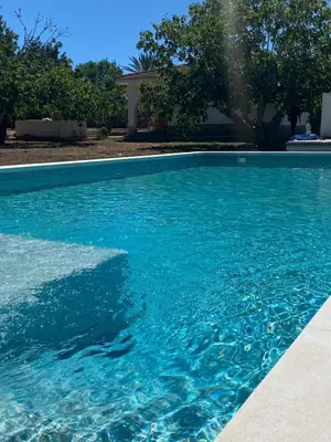 a swimming pool with blue water in a yard at villa eloisa in Chiclana de la Frontera