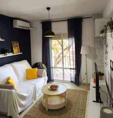 a living room with a white couch and a table at Apartamento V CENTENARIO BEACH Sanlúcar in Sanlúcar de Barrameda