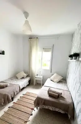 a bedroom with two beds and a window at Apartamento V CENTENARIO BEACH Sanlúcar in Sanlúcar de Barrameda