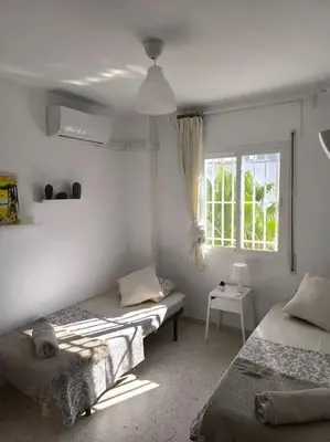 a bedroom with two beds and a window at Apartamento V CENTENARIO BEACH Sanlúcar in Sanlúcar de Barrameda