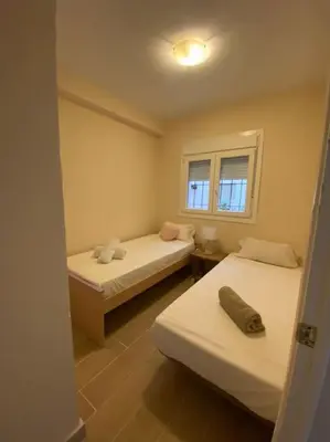 a small room with two beds and a window at Delfín Avenida Ha in Cádiz