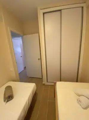 a small room with two beds and a door at Delfín Avenida Ha in Cádiz