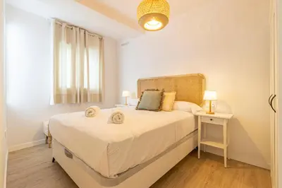 a bedroom with a large white bed and a window at Allo Apartments Morenos IV Bajo B Centro 2 Habitaciones in Jerez de la Frontera