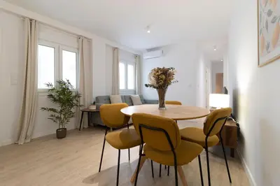 a dining room with a table and yellow chairs at Allo Apartments Morenos IV Bajo B Centro 2 Habitaciones in Jerez de la Frontera