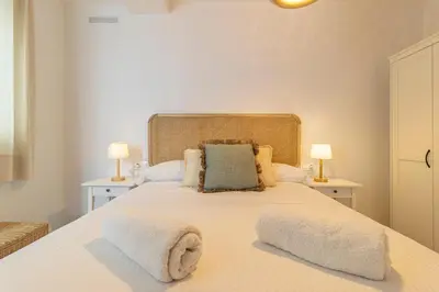 a bedroom with a large white bed with two lamps at Allo Apartments Morenos IV Bajo B Centro 2 Habitaciones in Jerez de la Frontera