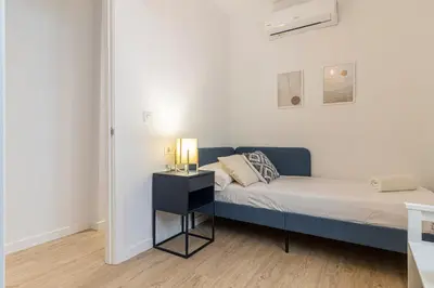 a bedroom with a bed and a night stand with a lamp at Allo Apartments Morenos IV Bajo B Centro 2 Habitaciones in Jerez de la Frontera