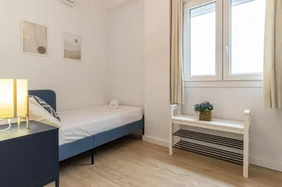 a small bedroom with a bed and a window at Allo Apartments Morenos IV Bajo B Centro 2 Habitaciones in Jerez de la Frontera