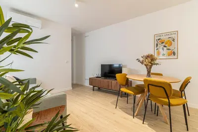 a living room with a table and chairs and a tv at Allo Apartments Morenos IV Bajo B Centro 2 Habitaciones in Jerez de la Frontera