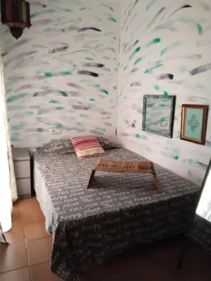 a bedroom with a bed with a fish patterned wall at Bienvenidos Villa Roki Para información seis3tres 0nueve 0nueve veinte in El Puerto de Santa María