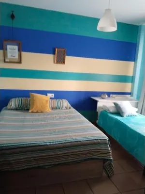 a bedroom with a blue and white striped wall at Bienvenidos Villa Roki Para información seis3tres 0nueve 0nueve veinte in El Puerto de Santa María