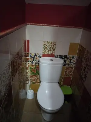 a white toilet in a bathroom with colorful tiles at Bienvenidos Villa Roki Para información seis3tres 0nueve 0nueve veinte in El Puerto de Santa María