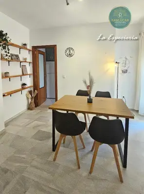 a wooden table and chairs in a room at La Especiería relax by Sanlúcar Housing in Sanlúcar de Barrameda