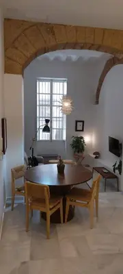 a dining room with a wooden table and chairs at el 2 de Flamenco BajoA in Cádiz