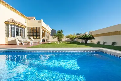 a swimming pool in front of a house at Chalet Silvia in Chiclana de la Frontera