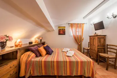 a bedroom with a bed and a desk and a tv at Chalet Silvia in Chiclana de la Frontera