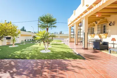 a courtyard of a building with palm trees at Chalet Silvia in Chiclana de la Frontera
