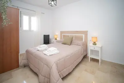 a bedroom with a bed with two towels on it at Piso en el Barrio Alto in Sanlúcar de Barrameda