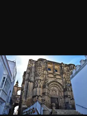 a tall stone building with a clock tower at Leo's Home in Arcos de la Frontera