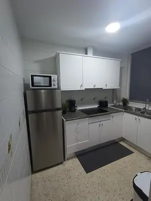 a kitchen with a stainless steel refrigerator and white cabinets at Leo's Home in Arcos de la Frontera