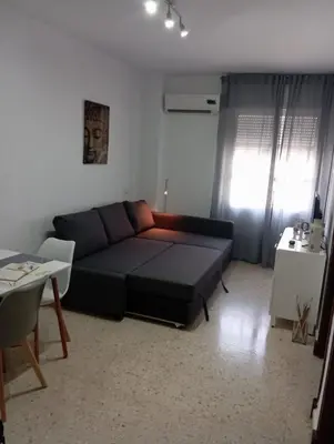 a living room with a black couch and a table at Leo's Home in Arcos de la Frontera