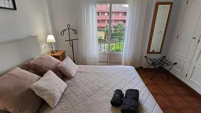 a bedroom with a bed with two pairs of shoes on it at Pantoque Sani Ideal para familias in El Puerto de Santa María
