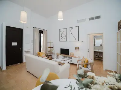 a living room with a white couch and a tv at Sibs Sanlucar Fariñas 11 Edif Historico Renovado Ideal Parejas in Sanlúcar de Barrameda