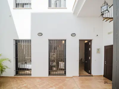 a white room with two doors with bars on them at Sibs Sanlucar Fariñas 11 Edif Historico Renovado Ideal Parejas in Sanlúcar de Barrameda