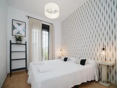 a white bedroom with a large white bed and a window at Sibs Sanlucar Fariñas 11 Edif Historico Renovado Ideal Parejas in Sanlúcar de Barrameda