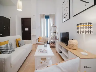 a living room with a white couch and a tv at Sibs Sanlucar Fariñas 11 Edif Historico Renovado Ideal Parejas in Sanlúcar de Barrameda